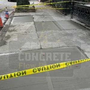 Repaired concrete sidewalk slabs taped off while curing