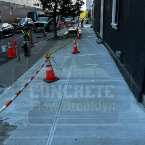 Freshly poured sidewalk protected by cones and caution tape